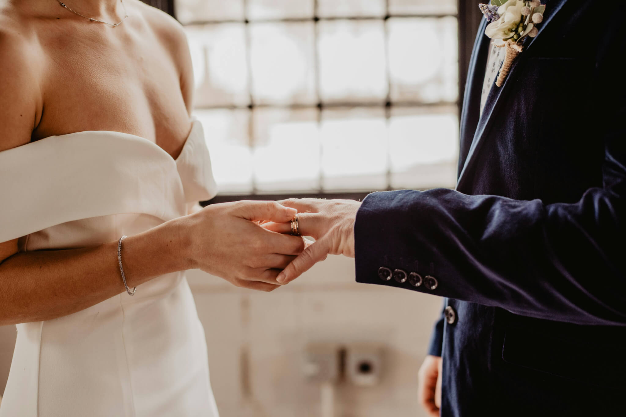 Newlywed couple exchanging wedding rings, symbolizing their union.