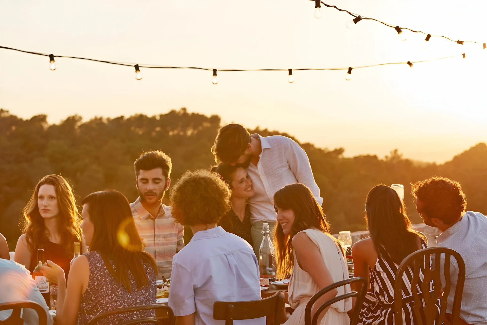 Friends celebrating and toasting outdoors at sunset at The Sanderling Hotel – unforgettable dining experience